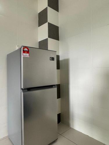 a stainless steel refrigerator in a corner of a room at Sekinchan 2008 Homestay Karaoke BBQ in Sekincan