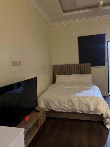 a bedroom with a bed and a flat screen tv at استيديو بالعقيق بدخول ذاتي c3 in Riyadh
