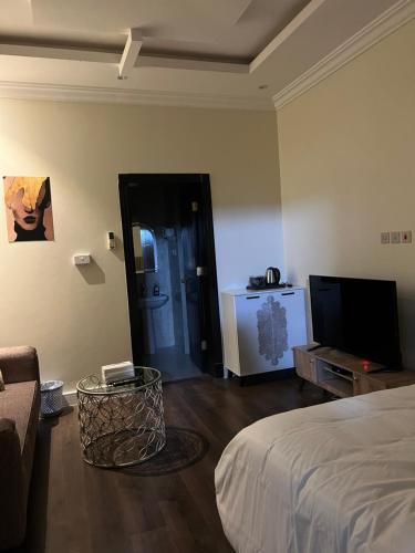 a bedroom with a bed and a tv and a couch at استيديو بالعقيق بدخول ذاتي c3 in Riyadh