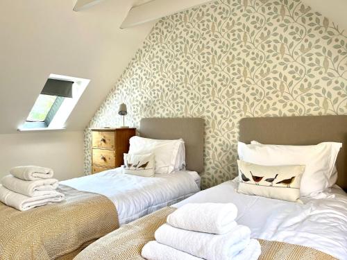 two beds sitting next to each other in a bedroom at Converted coach house with parking in Pittenweem in Pittenweem