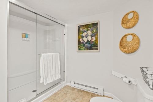 a white bathroom with a shower and a toilet at Walk To Parks, Dining & Lake! Game Room! Hot Tub! in Watkins Glen
