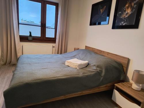 Un dormitorio con una cama con una toalla. en Apartament Optymalny, en Tczew