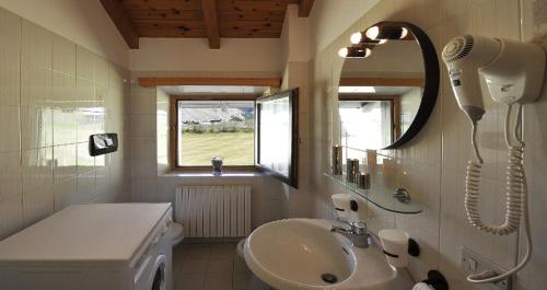 une salle de bain avec un lavabo et un sèche-cheveux dans l'établissement Ski Holidays Apartments, à Livigno