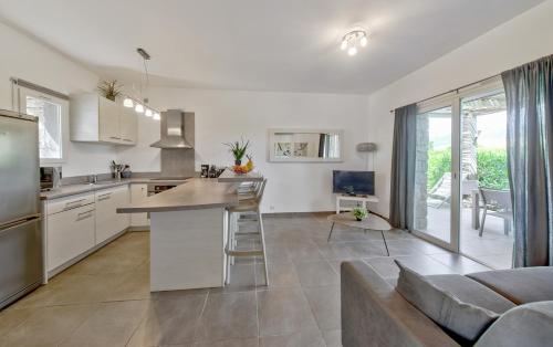 une cuisine et un salon avec un canapé dans l'établissement Résidence Pierre & Vacances Premium Les Villas de Porto-Vecchio, à Porto-Vecchio