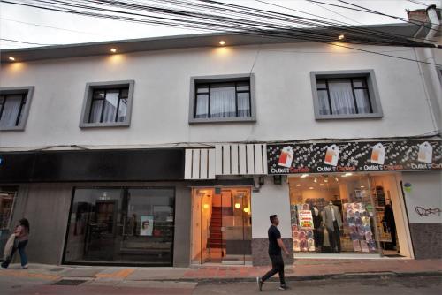 un hombre caminando delante de una tienda en Casa Blanca Hospedaje, en Pasto