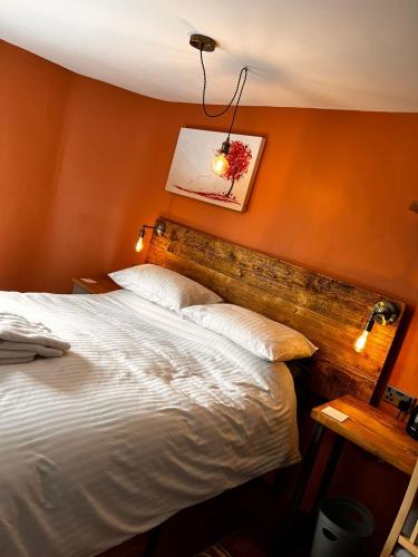 a bedroom with a large bed with an orange wall at Old Manor House in Axbridge