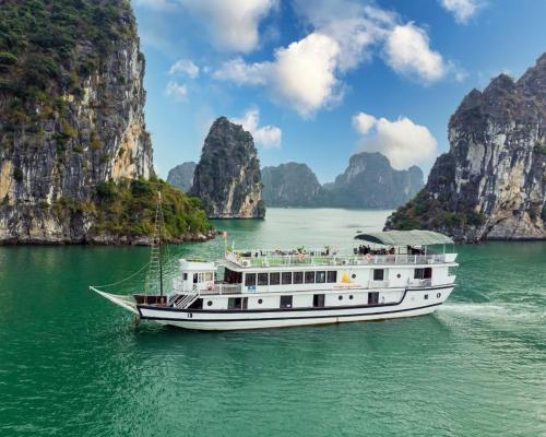 a boat in a body of water with mountains at Hanoi EcoStay 1 hostel in Hanoi