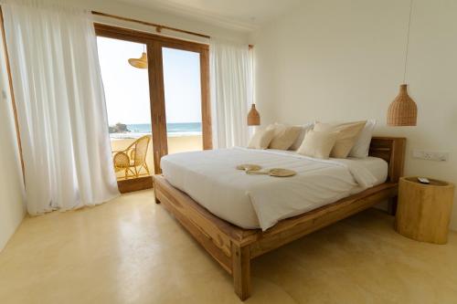 Schlafzimmer mit einem Bett und Strandblick in der Unterkunft Blue Waves Surf Hotel Sri Lanka in Ahangama