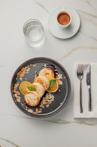 a plate of food on a table with a cup of coffee at Modern Art Hotel in Lviv