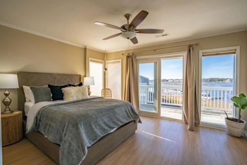 1 dormitorio con 1 cama, ventilador de techo y ventanas en Waterfront Condo Carolina Beach en Carolina Beach