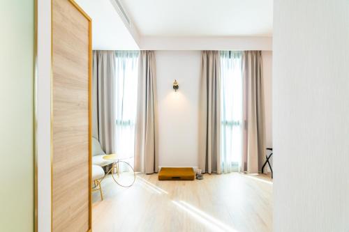 een woonkamer met witte muren en een grote spiegel bij Hotel Málaga Vibes in Málaga