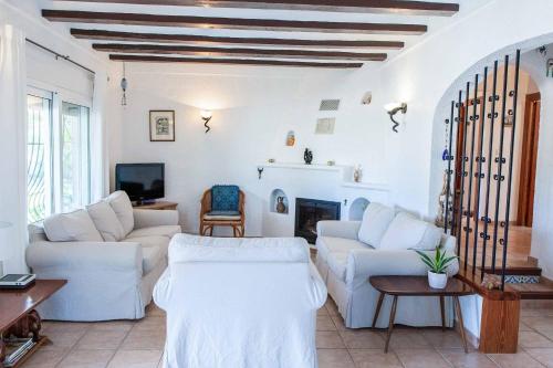 a living room with white furniture and a fireplace at Villa La Paz in El Tosalet