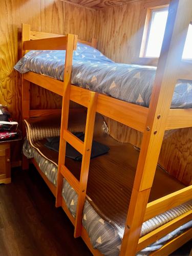 two bunk beds in a cabin with a window at Espectacular Cabaña en Castro in Castro