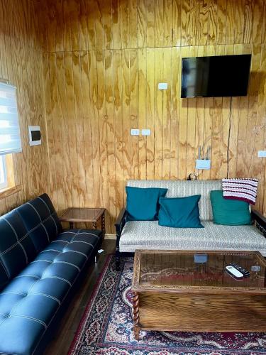 a living room with a couch and a tv at Espectacular Cabaña en Castro in Castro