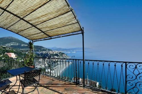 a balcony with a table and a view of the water at In Costa Relais & Luxury Suites in Vietri sul Mare