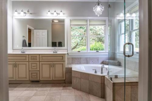 a bathroom with a tub and a sink and a mirror at Sleeps 14 - Pinehurst in Pinehurst