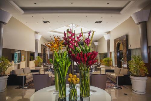 a lobby with vases filled with flowers on a table at Windsor Barra Hotel in Rio de Janeiro