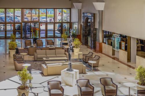 a lobby with couches and chairs in a building at Windsor Barra Hotel in Rio de Janeiro