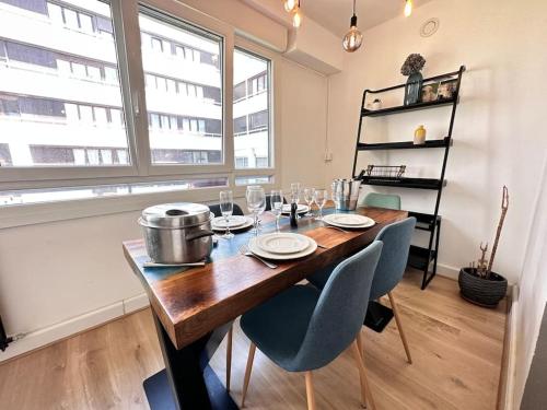une salle à manger avec une table et des chaises en bois dans l'établissement Henri/ 3 chambres vue sur le canal et la basilique, à Reims