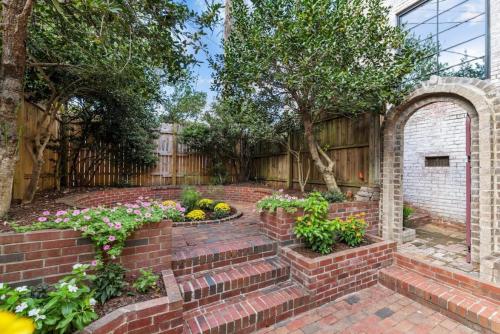 a brick garden with an arch and some flowers at Slice of Seclusion in Downtown Southern Pines in Southern Pines