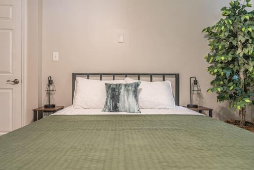1 cama con edredón verde y almohada en Maine Avenue- Downtown Southern Pines, en Southern Pines