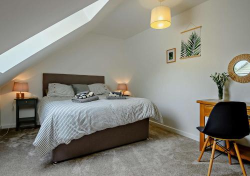a white bedroom with a bed and a chair at No 5 Hedgehog Den 