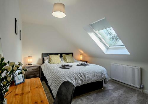 a bedroom with a large bed with a skylight at No 6 Deer Glade in Sparham