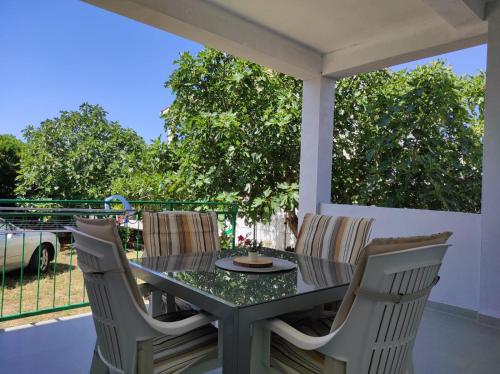a table and chairs on a patio with a view at Apartment with Terrace and Garden in Pirovac
