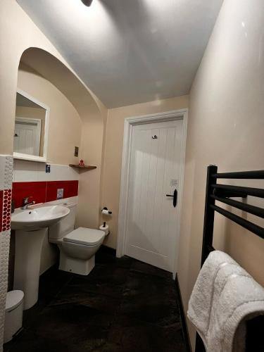 a bathroom with a white toilet and a sink at Old Manor House in Axbridge