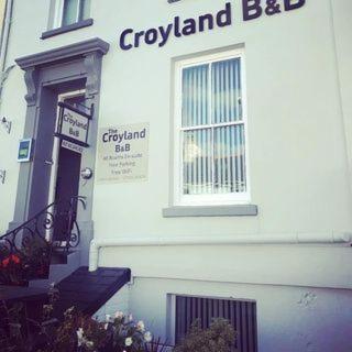 a white building with a sign on the side of it at Croyland Guest House in Tenby