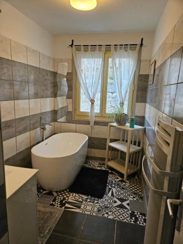 een badkamer met een bad en een raam bij Honey Moon in Saint-Bonnet-en-Champsaur