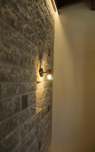 a light on a brick wall in a room at MAKRIS Papigo Luxury suites in Papigko