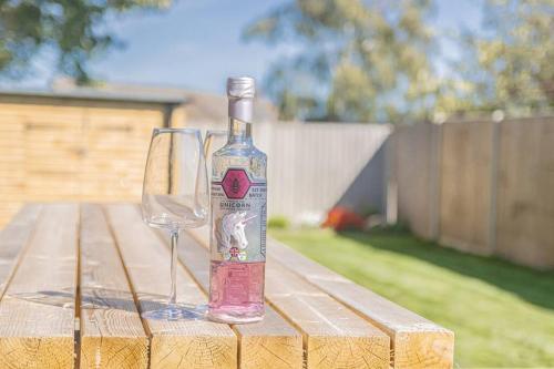 a bottle of wine sitting on a table with a wine glass at The Annexe Close to Dover Port in River