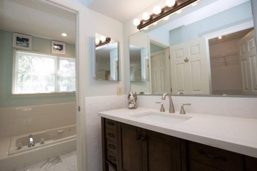 een badkamer met een wastafel en een grote spiegel bij Sleeps 6- in Pinehurst in Pinehurst