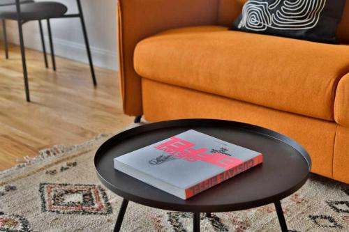 - un livre sur une table basse dans le salon dans l'établissement Modern apartment - 1BR-4P - Canal St-Martin, à Paris