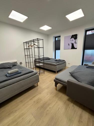 two beds in a room with wooden floors and windows at wobStay family & fitters in Worbis