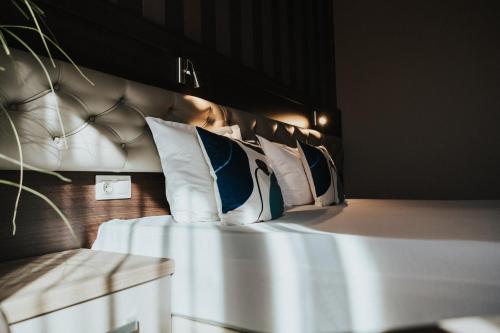 a bedroom with a bed with pillows on it at Business Hotel Plovdiv - Central Location in Plovdiv