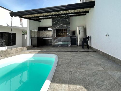 patio trasero con piscina, cocina y nevera en Casa Temporada Rio Quente (Em frente ao Hot Park) in 
