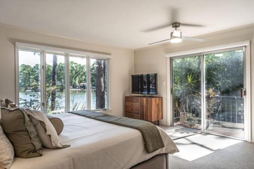 um quarto com uma cama grande e uma janela grande em Sleeps 6-Whispering Pines Lake Front 