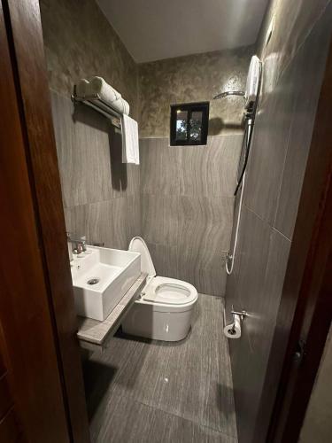 a small bathroom with a toilet and a sink at RL Harbor Inn in El Nido