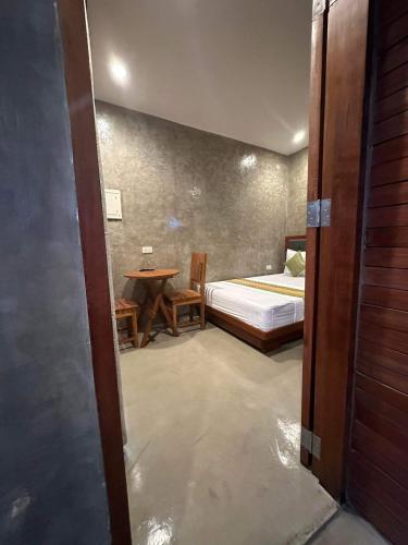 a bedroom with a bed and a table in a room at RL Harbor Inn in El Nido