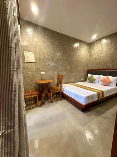 a bedroom with a bed and a table in it at RL Harbor Inn in El Nido