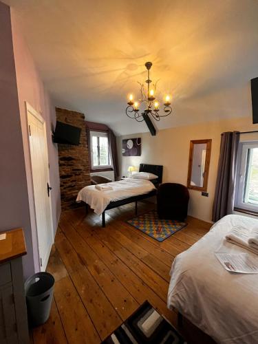 a room with two beds and a chandelier at Old Manor House in Axbridge