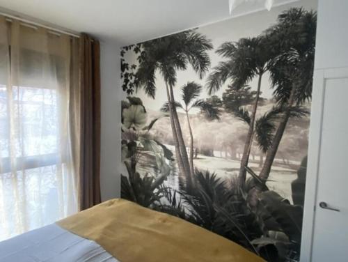 un cuadro en la pared de un dormitorio con palmeras en Apartamento Ginestar en Malaga, en Málaga