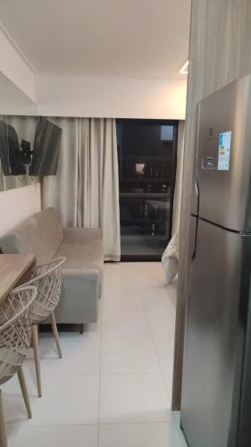 a living room with a refrigerator and a couch at Flat Makia Beach Experience Muro Alto in Porto De Galinhas