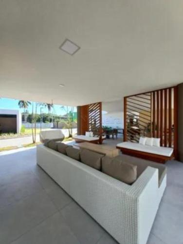 a living room with a long white couch at Flat Makia Beach Experience Muro Alto in Porto De Galinhas