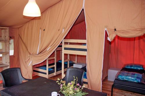FuillaにあるCamping le Rotjaの二段ベッド2台、テーブル、椅子が備わる客室です。