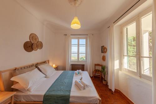 ein Schlafzimmer mit einem Bett und zwei Fenstern in der Unterkunft Near Cinque Terre - Mountain Farmhouse with Pool in Tivegna