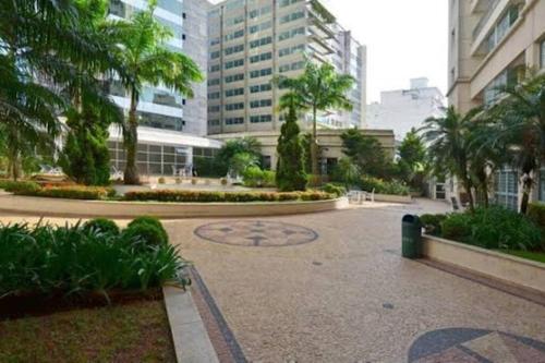 a courtyard with palm trees in a city with buildings at Apartamento Paulista in São Paulo