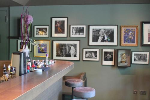 a bar with framed pictures on the wall at Hotel Stadtpalais in Cologne